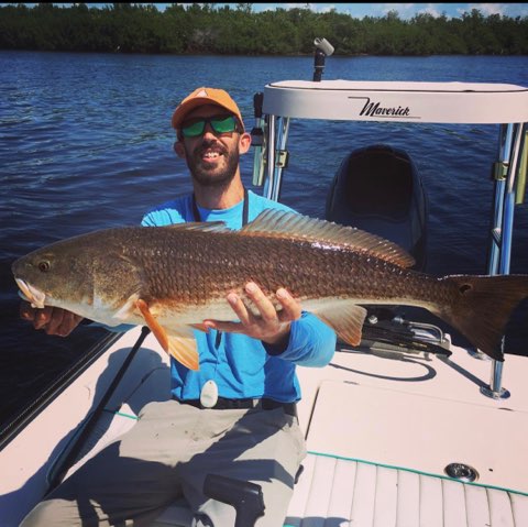 A large redfish is held up.