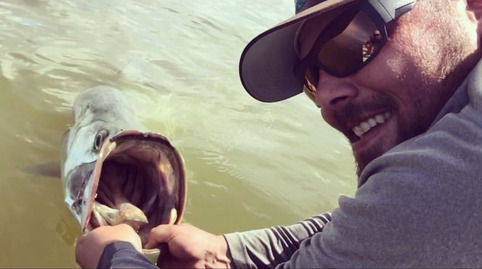Captain Craig displays a tarpon half submerged.